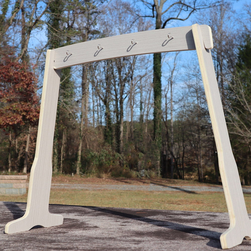 White wooden coat rack with hooks on a freestanding frame for home organization