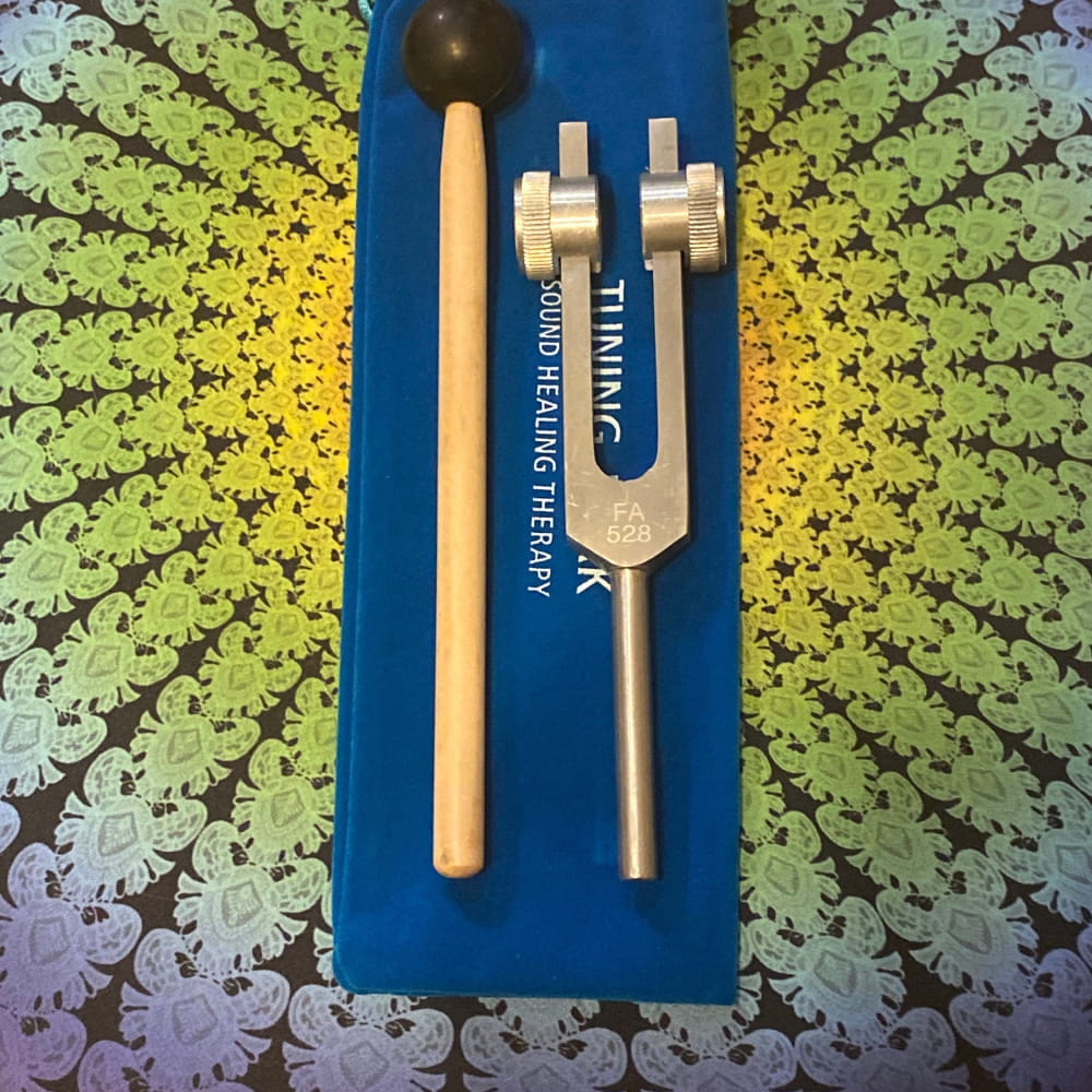 528 Hz Crystal-End Solfeggio Tuning Fork with mallet on blue surface for healing