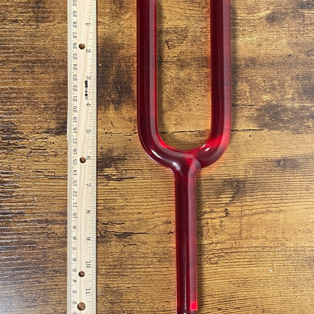 Red metallic tuning fork for sound healing and chakra therapy, 528Hz frequency