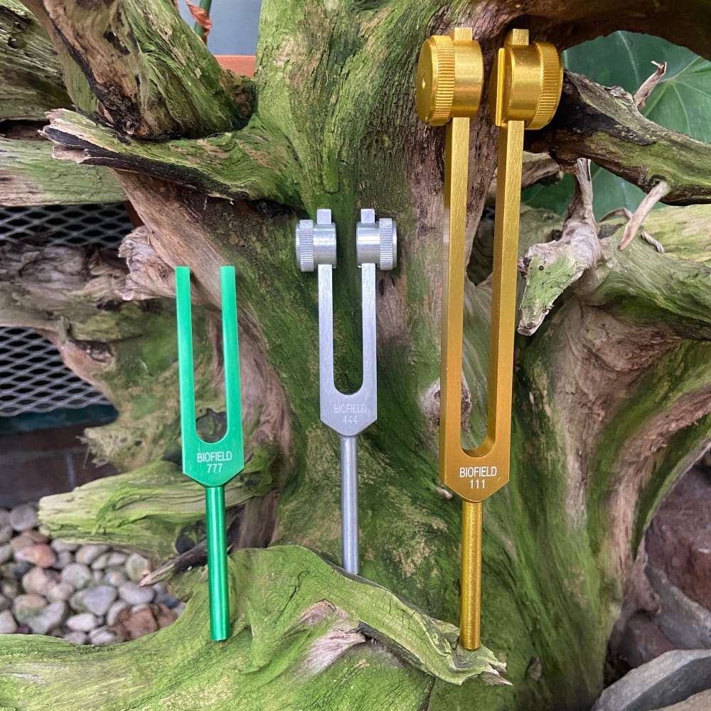 Three colorful tuning forks in turquoise, silver, and gold from 5pc Tuning Fork Set