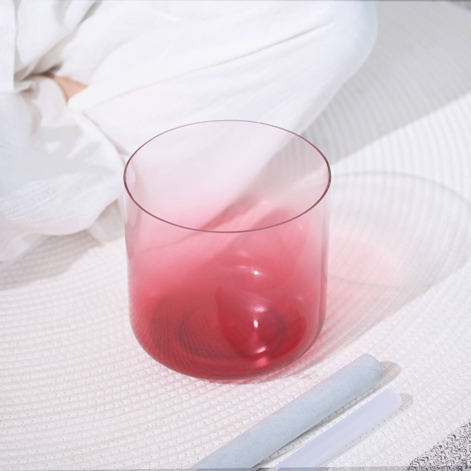 Glass tumbler with pink-red beverage next to 6-7 inch Crystal Singing Bowl