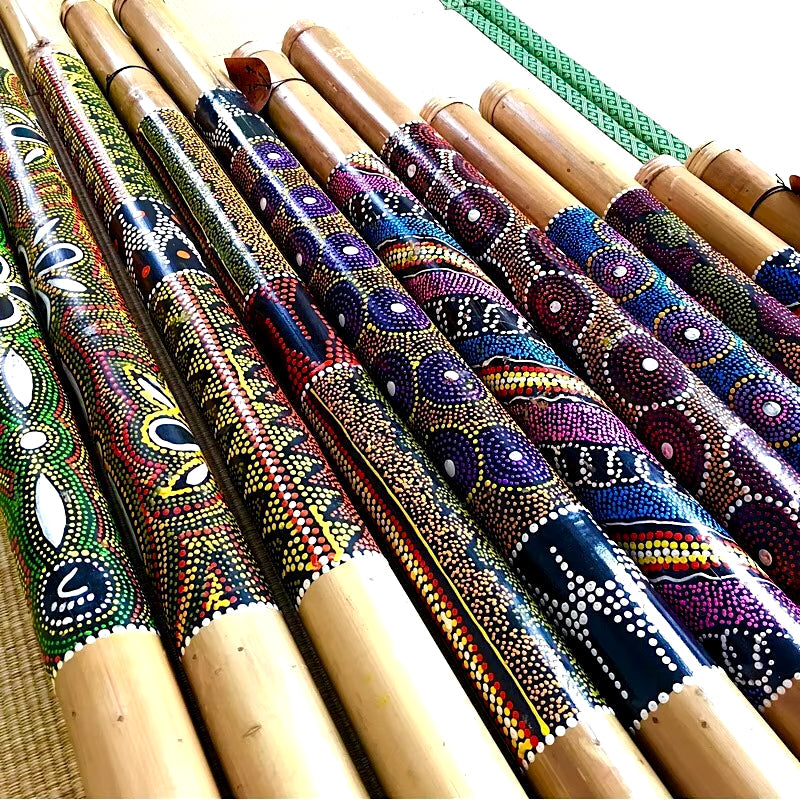 Decoratively painted wooden didgeridoos with vibrant dot patterns and designs