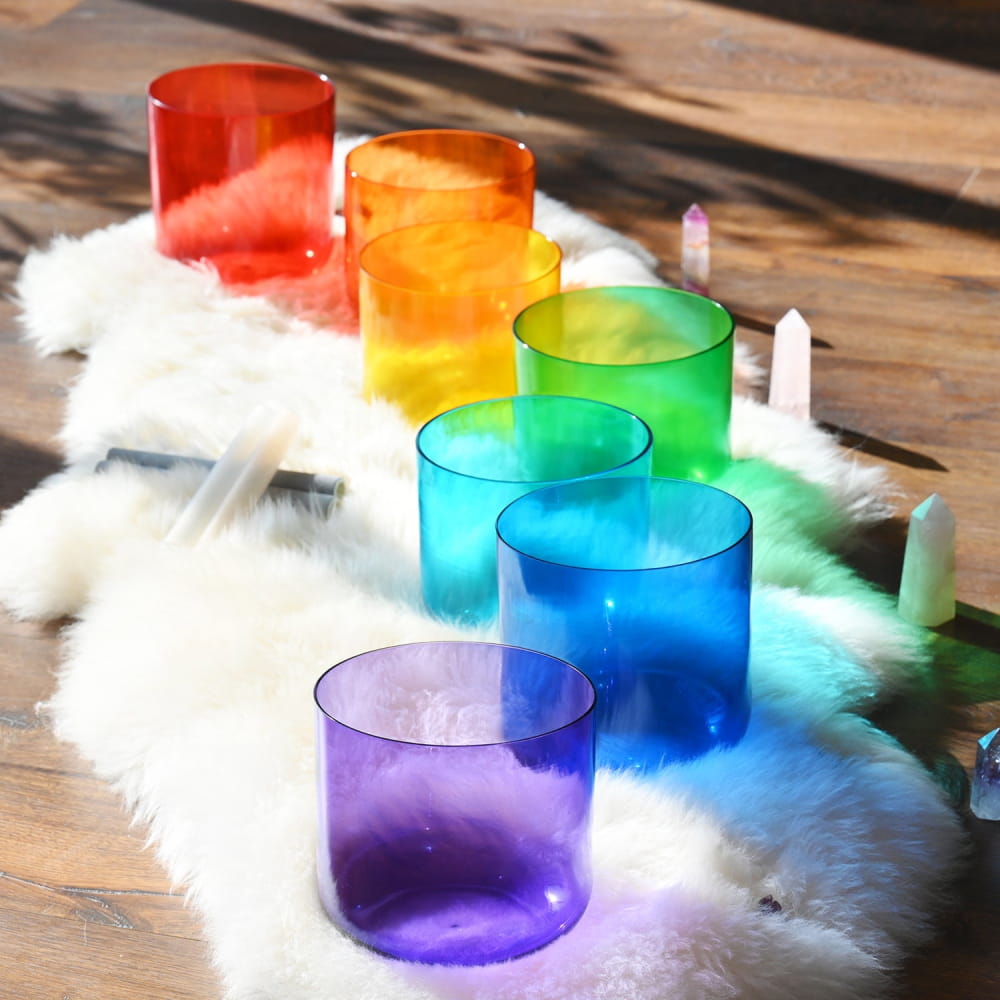 Rainbow-colored glass cups arranged in a spectrum for 7 PCS Alchemy Clear Color Crystal Singing Bowl Set