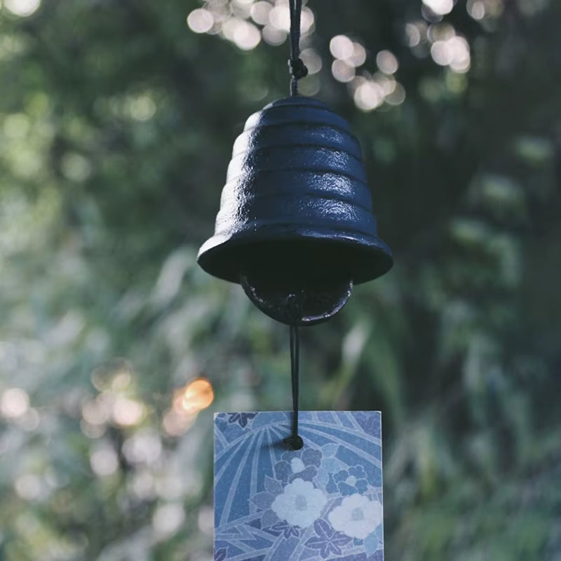 Dark blue bell-shaped Japanese cast iron wind chime with decorative tag for garden decor