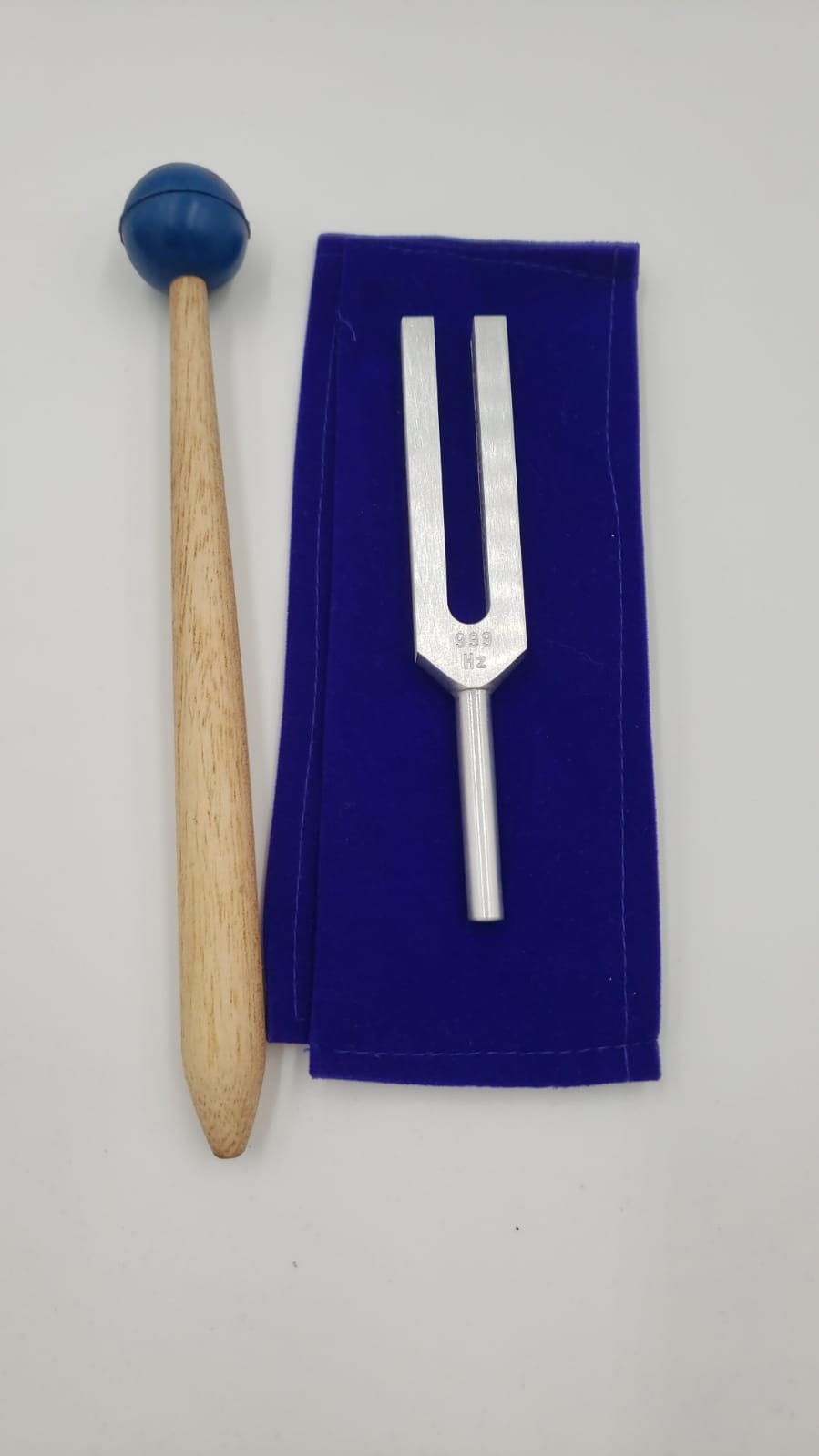 999 Hz Tuning Fork with Striker Set on blue cloth for healing and sound therapy