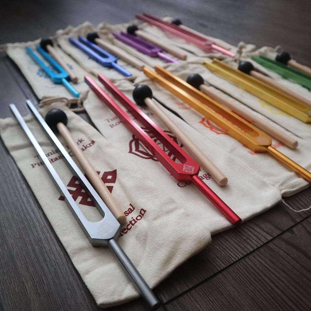 Colorful tuning forks arranged on fabric roll in 9pc Solfeggio Tuning Fork Set