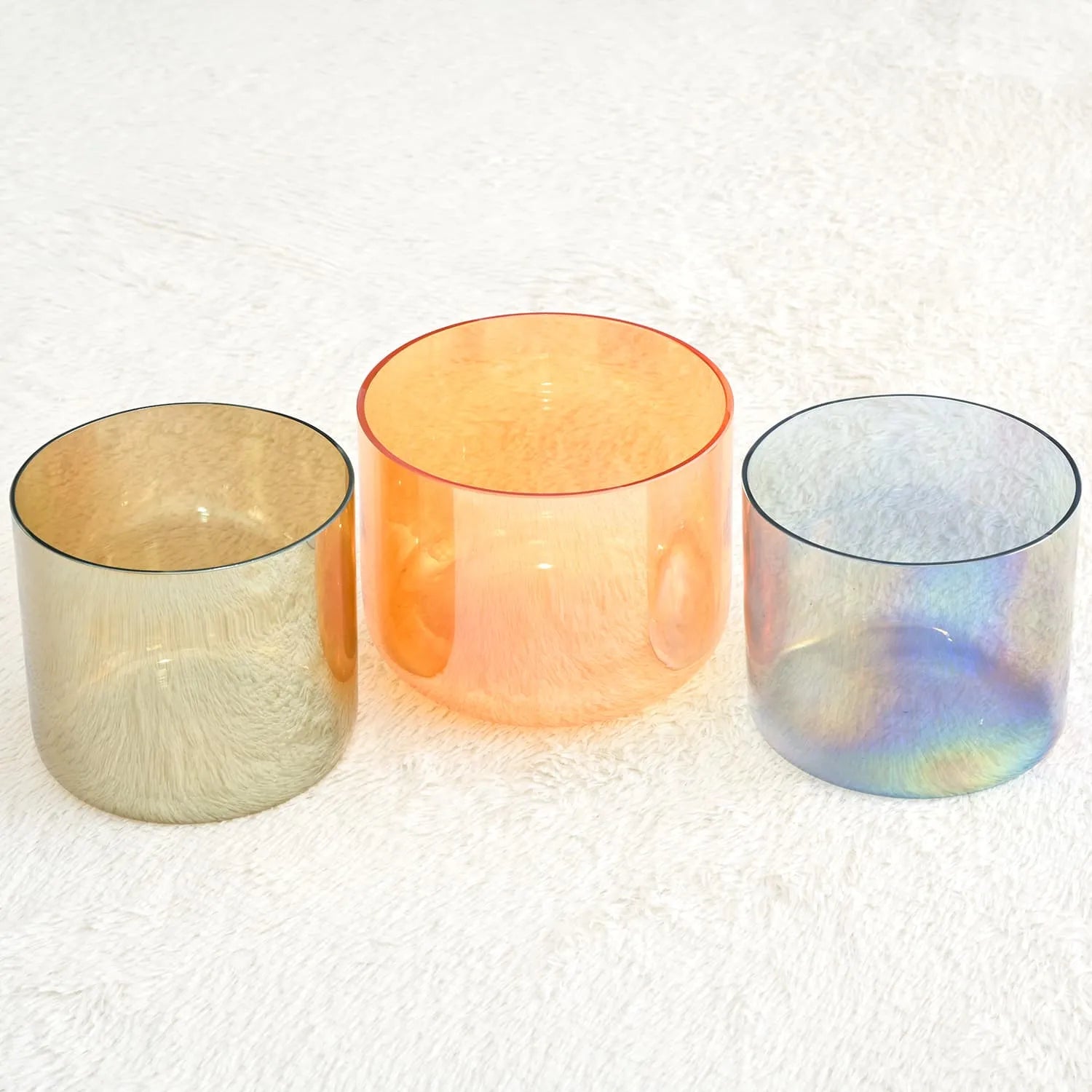 Translucent glass bowls in beige, peach, and iridescent blue for sound bath set