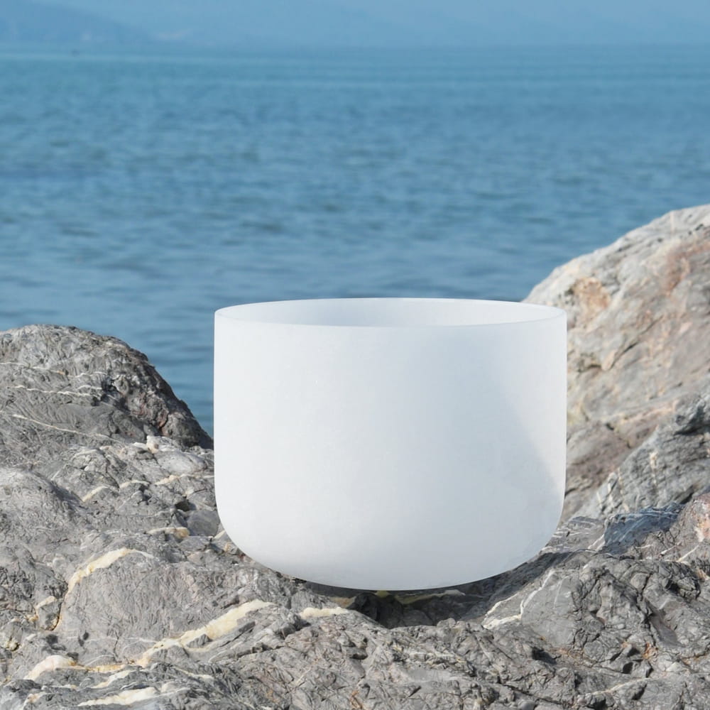 White crystal singing bowl on rocks for B Note Crown Chakra meditation healing