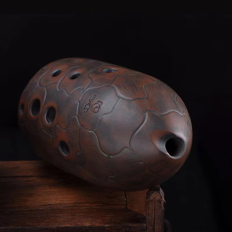 Brown ceramic ocarina with world map design and multiple finger holes for beginners