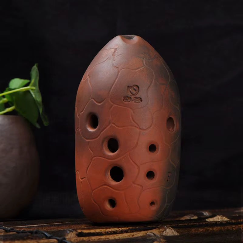 Terra cotta ocarina with carved patterns, finger holes in Beginner Xun Instrument