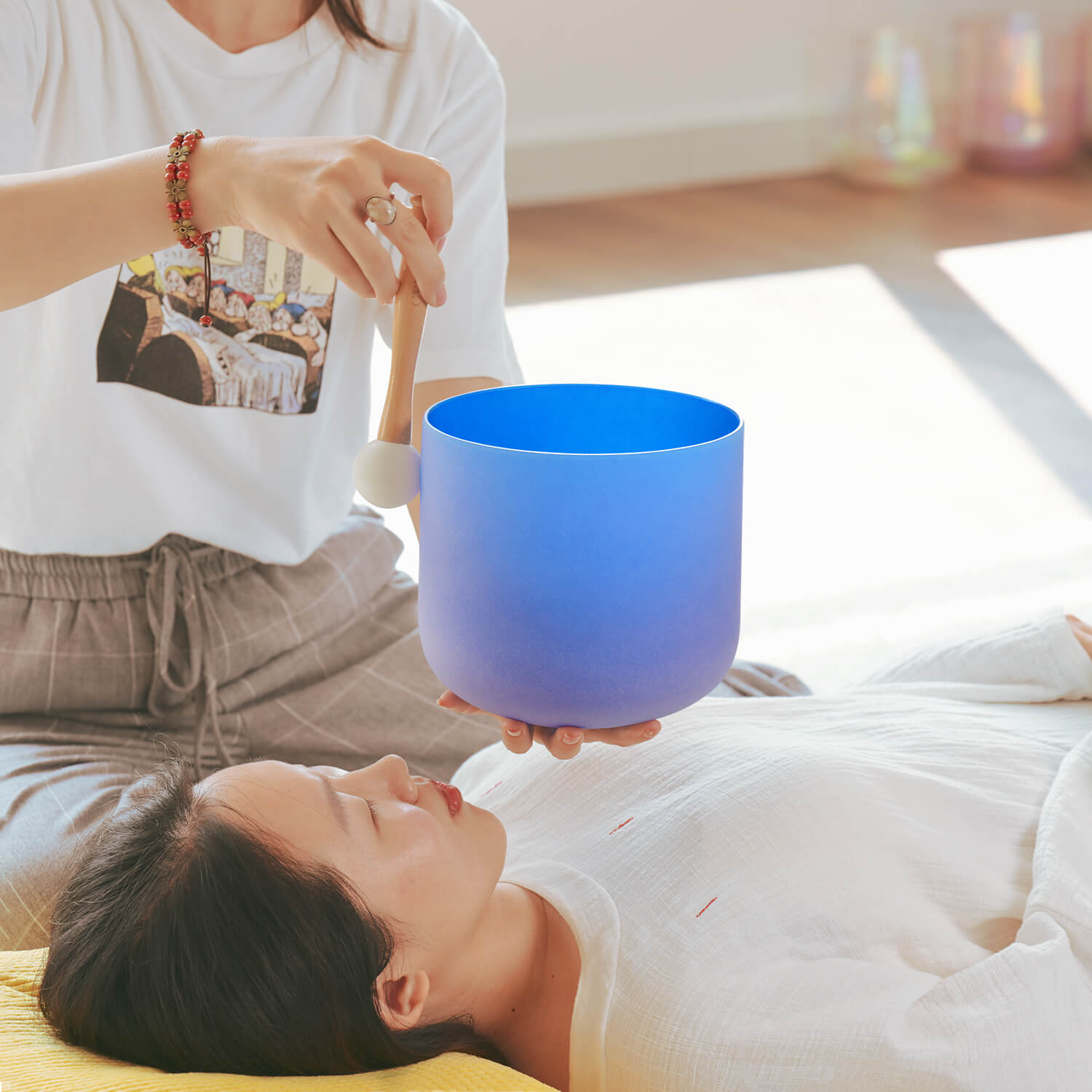 Bright blue crystal singing bowl used in sound healing session for throat chakra