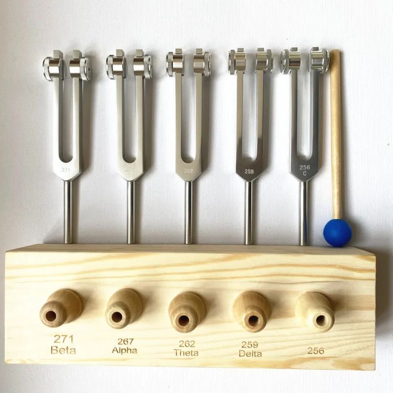 Medical tuning forks in a wooden holder with labeled frequencies for brain wave therapy