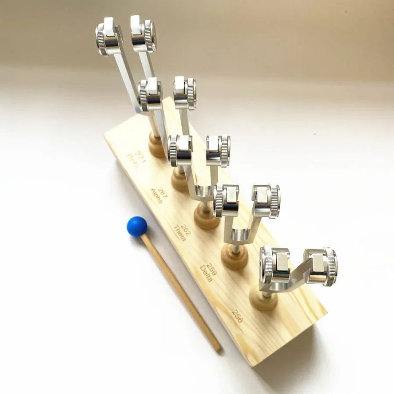 Brain Wave Tuning Fork Set with Stand arranged on a wooden base with striking mallet