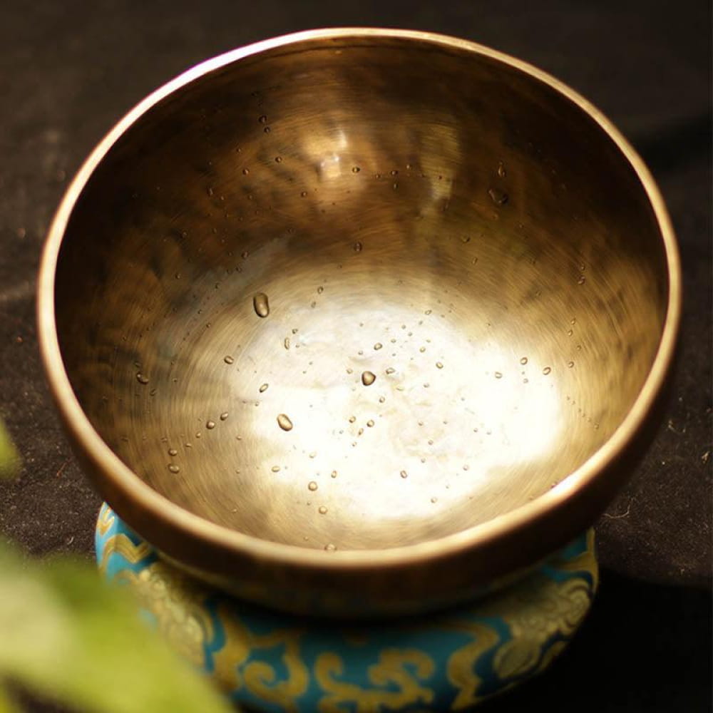 Metallic Tibetan Singing Bowl with water droplets, perfect for meditation