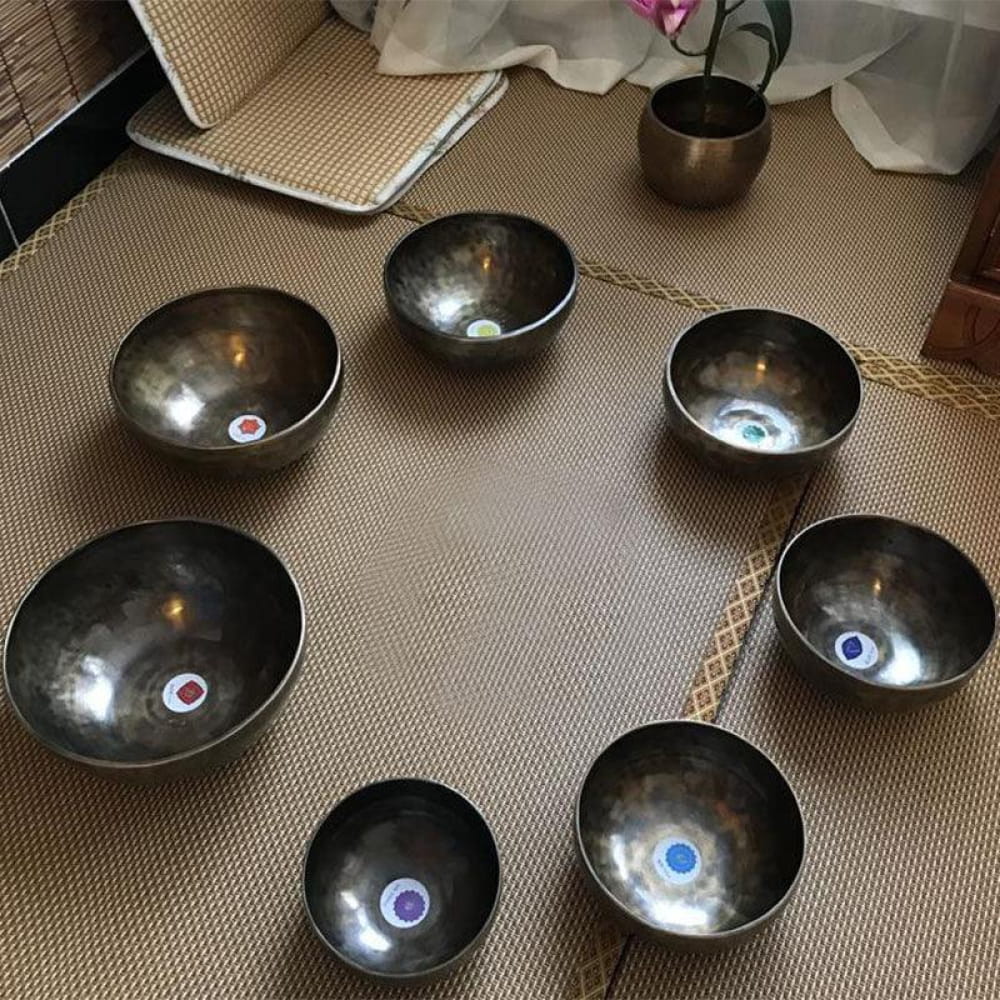 Seven dark metallic Tibetan singing bowls in a circular arrangement for meditation