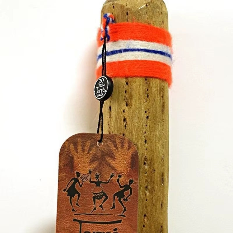 Driftwood rainstick instrument with orange stripes and leather tag featuring dancing figures