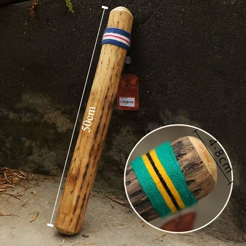 Wooden cricket bat with red and blue grip, detail of green and yellow stripes