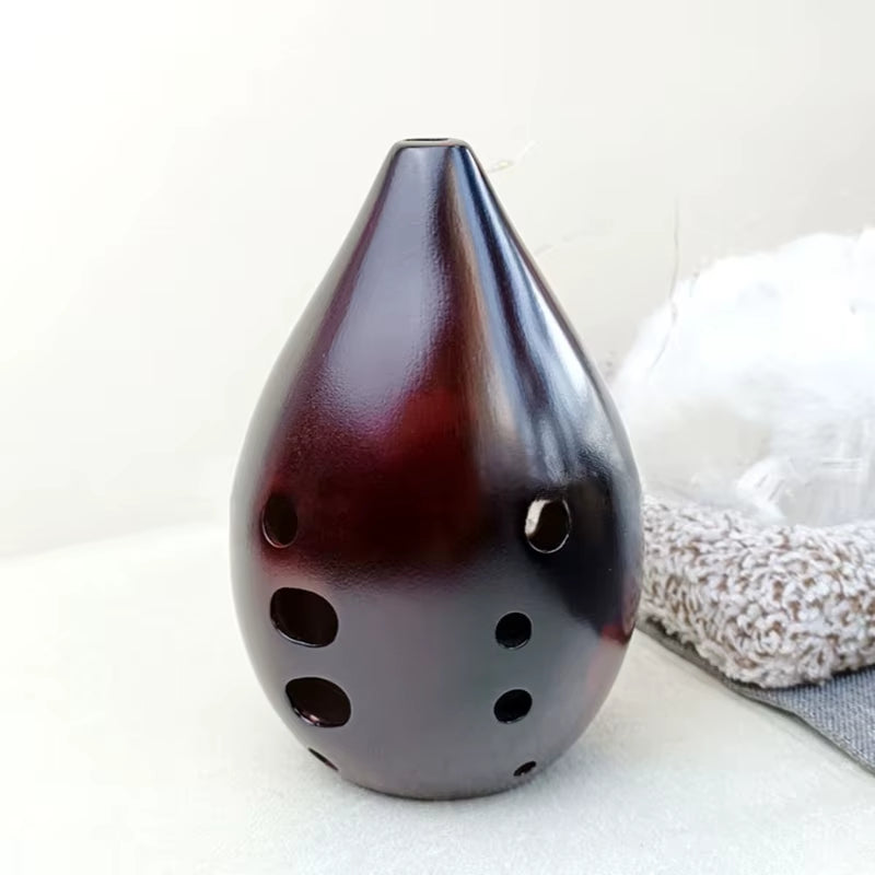 Dark brown teardrop-shaped Ceramic Xun with 10 circular holes for music play