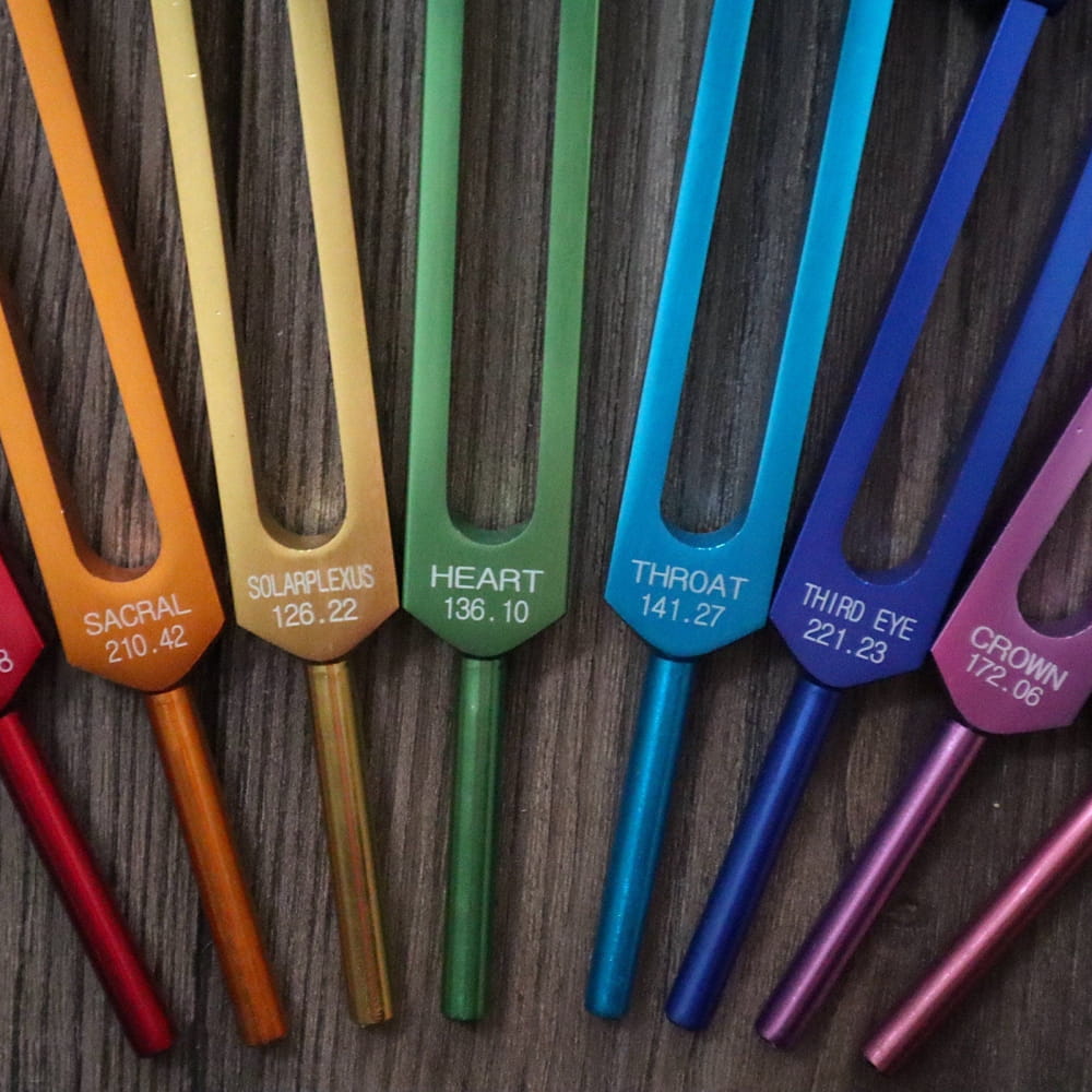 Colorful Chakra Healing Tuning Forks arranged in a vibrant rainbow spectrum