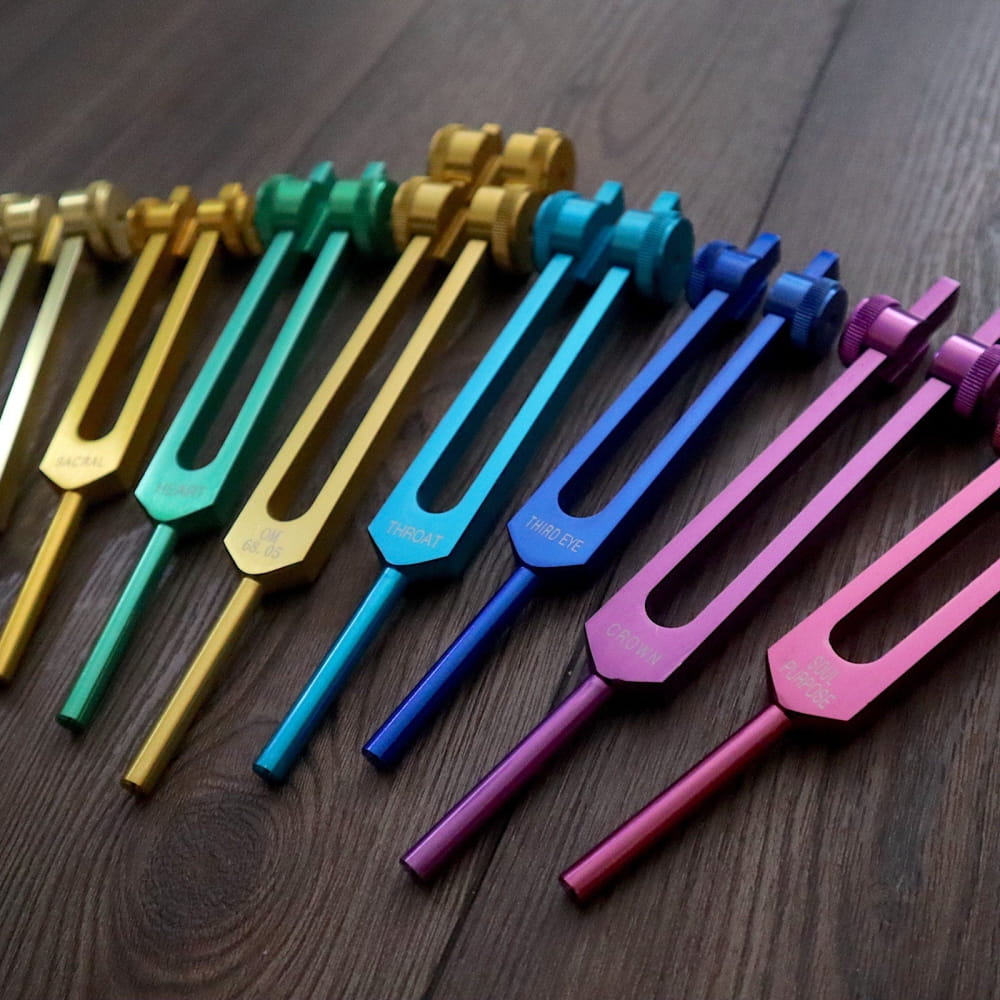 Colorful Chakra Healing Tuning Forks arranged in a rainbow gradient for energy balance