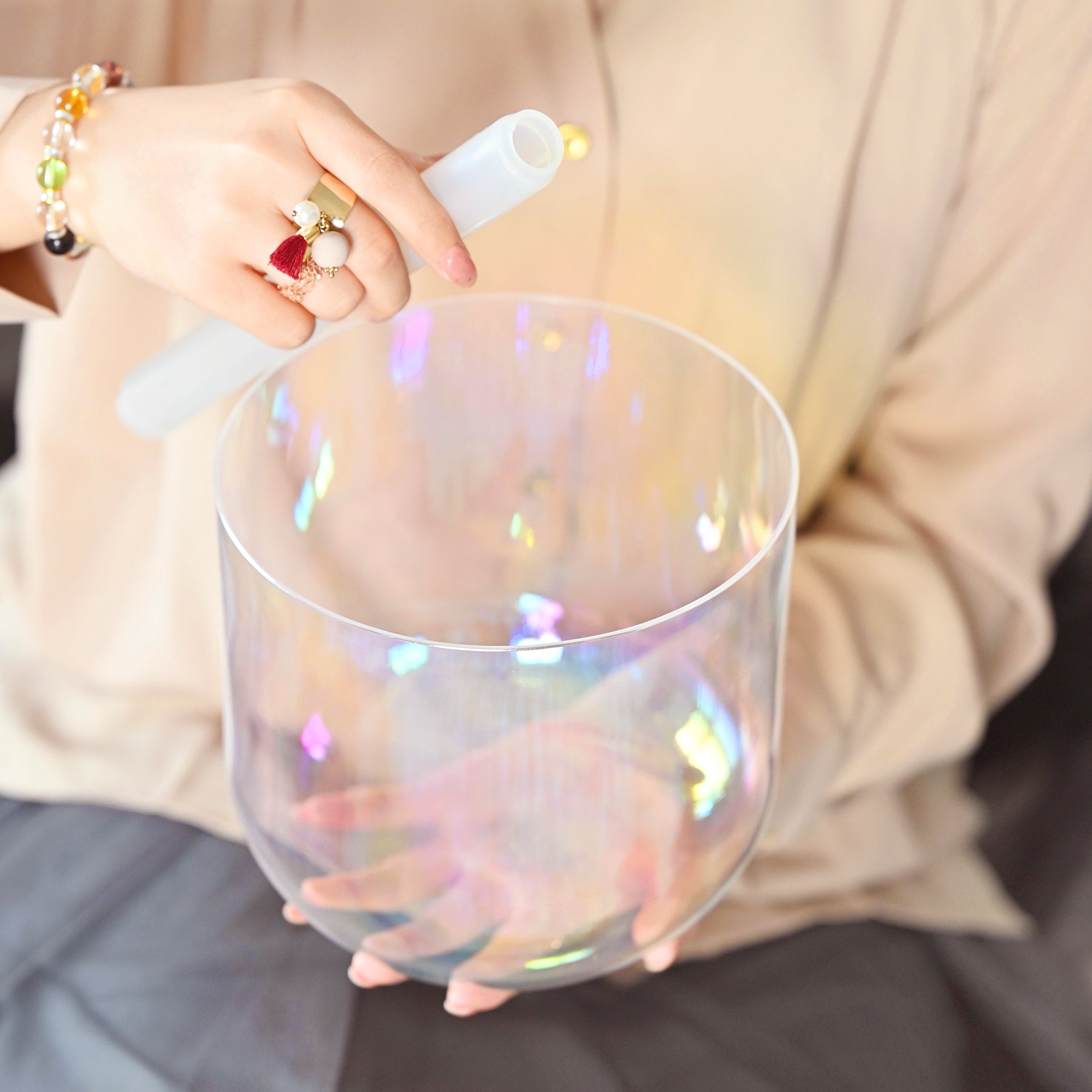 Iridescent glass cup reflecting rainbows beside Clear Rainbow Quartz Crystal Singing Bowl