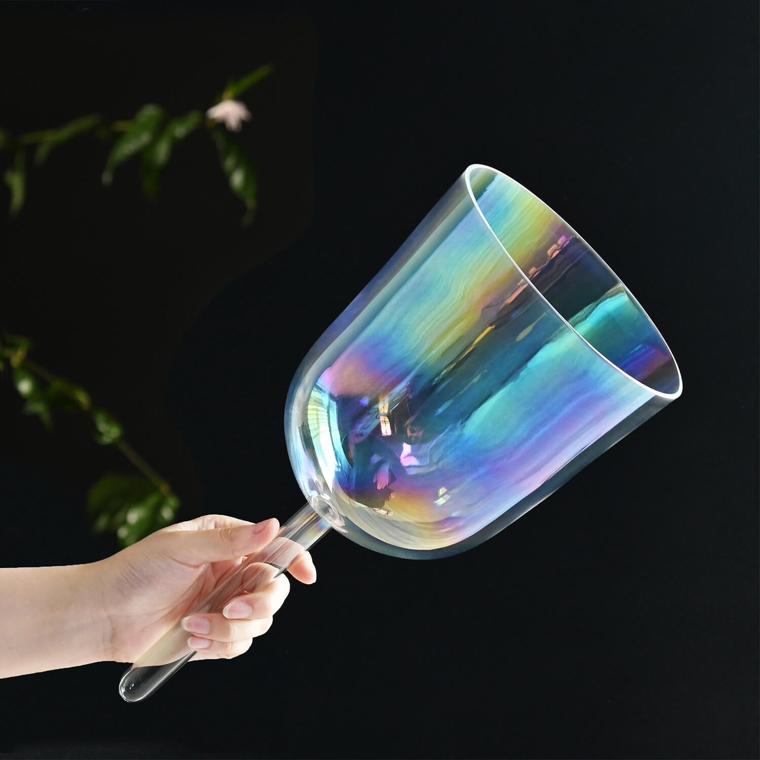 Iridescent glass wine goblet with rainbow sheen next to Crystal Singing Bowl with Handle