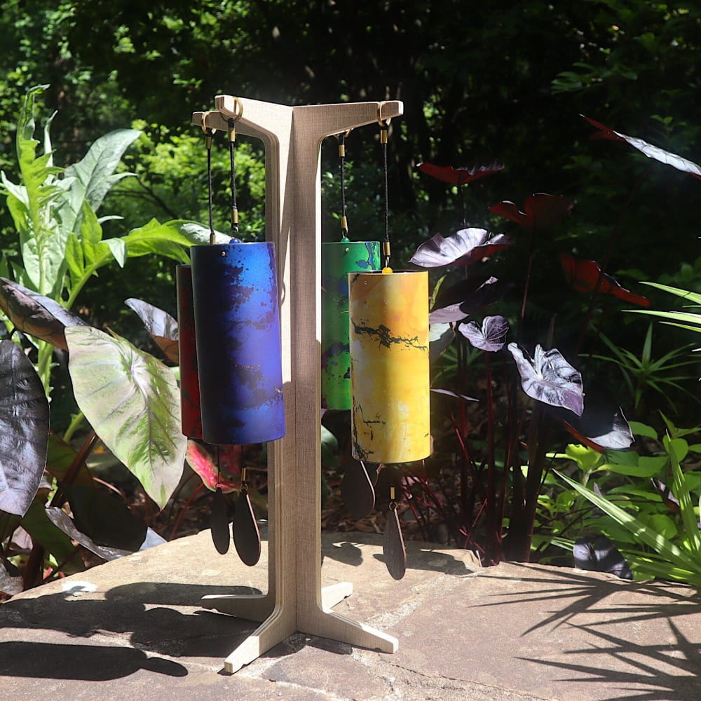 Wooden stand displaying colorful Koshi chimes featuring Terra, Aqua, Aria, and Ignis