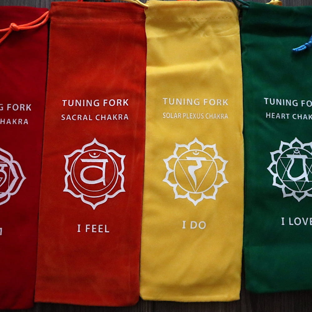 Colorful fabric pouches for tuning forks with chakra symbols and affirmations