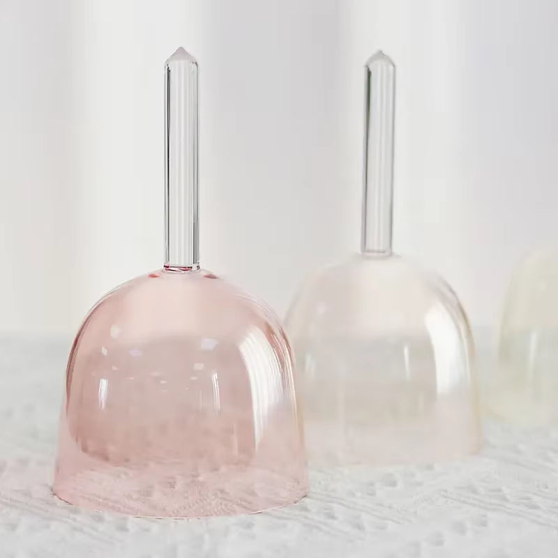 Two colorful crystal singing bells in pink and clear with long handles