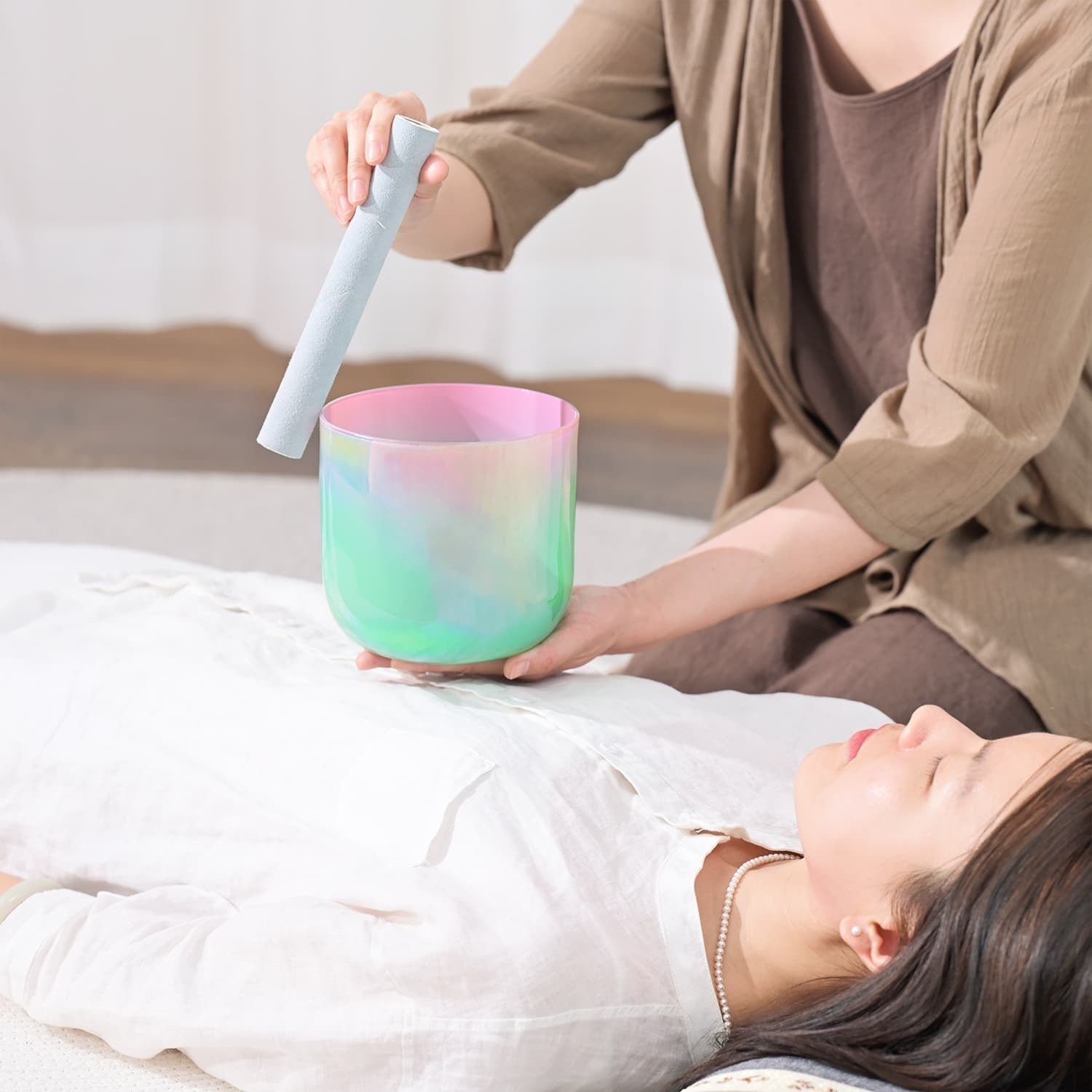 Crystal Singing Bowl Green Pink played with mallet in a sound healing session