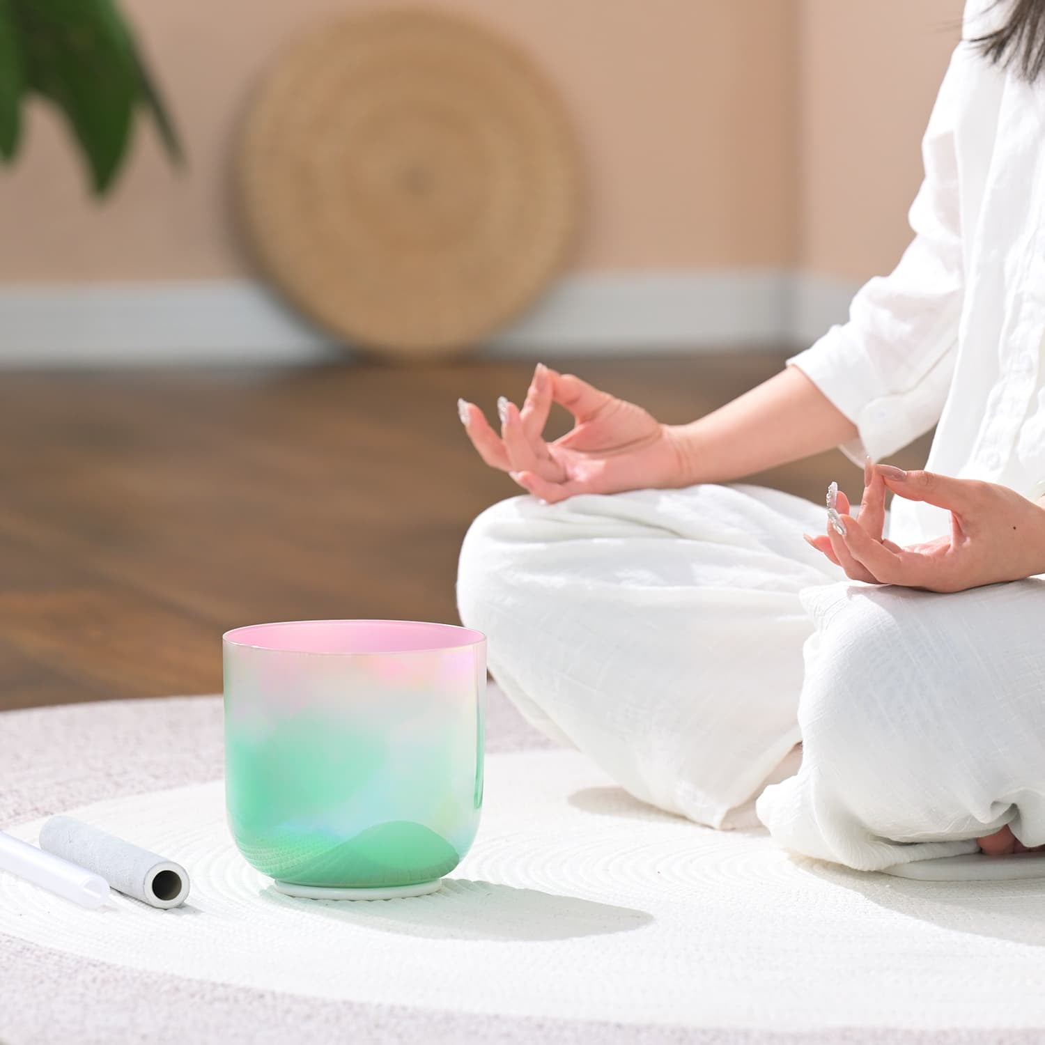 Pink and mint green gradient Crystal Singing Bowl for sound healing on a white surface