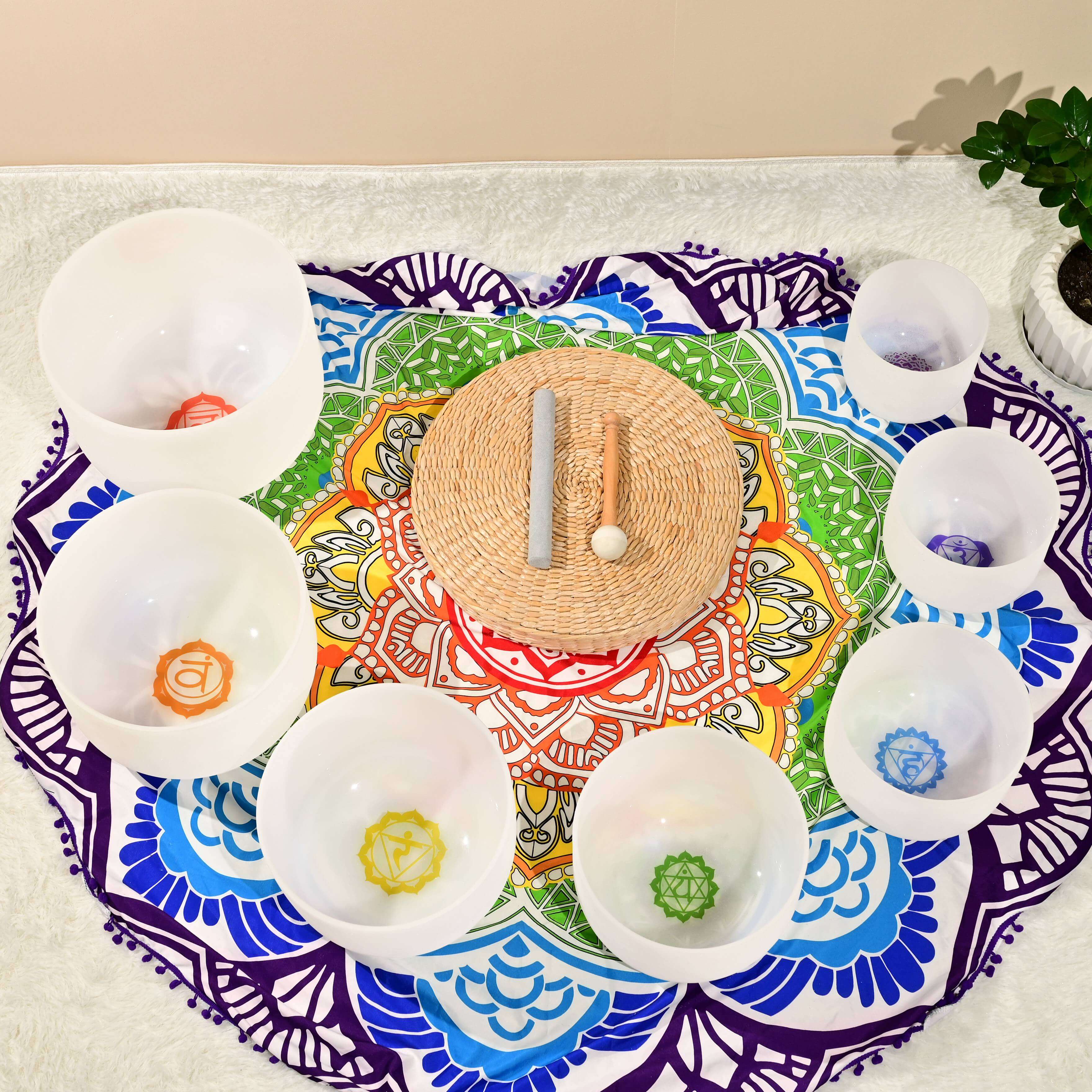 Colorful mandala placemat with white bowls around a Chakra Crystal Singing Bowl Set