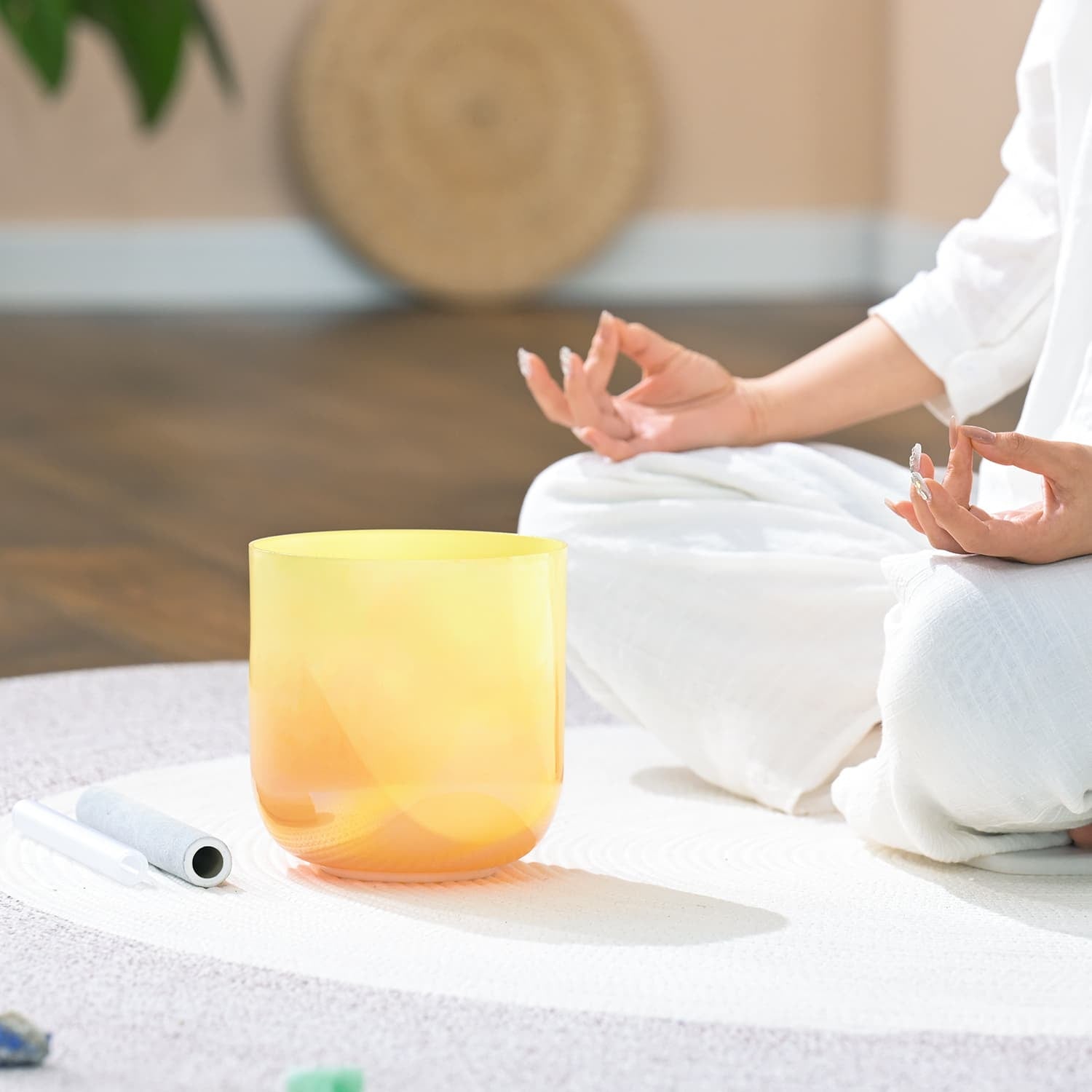 Yellow Crystal Singing Bowl beside meditation hands for sound healing therapy