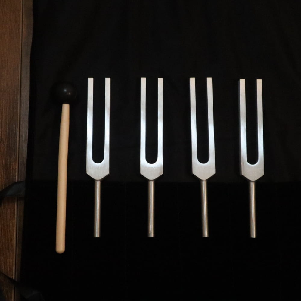 Four tuning forks and a mallet for DNA Nucleotide Tuning Fork Set in Biofield Therapy