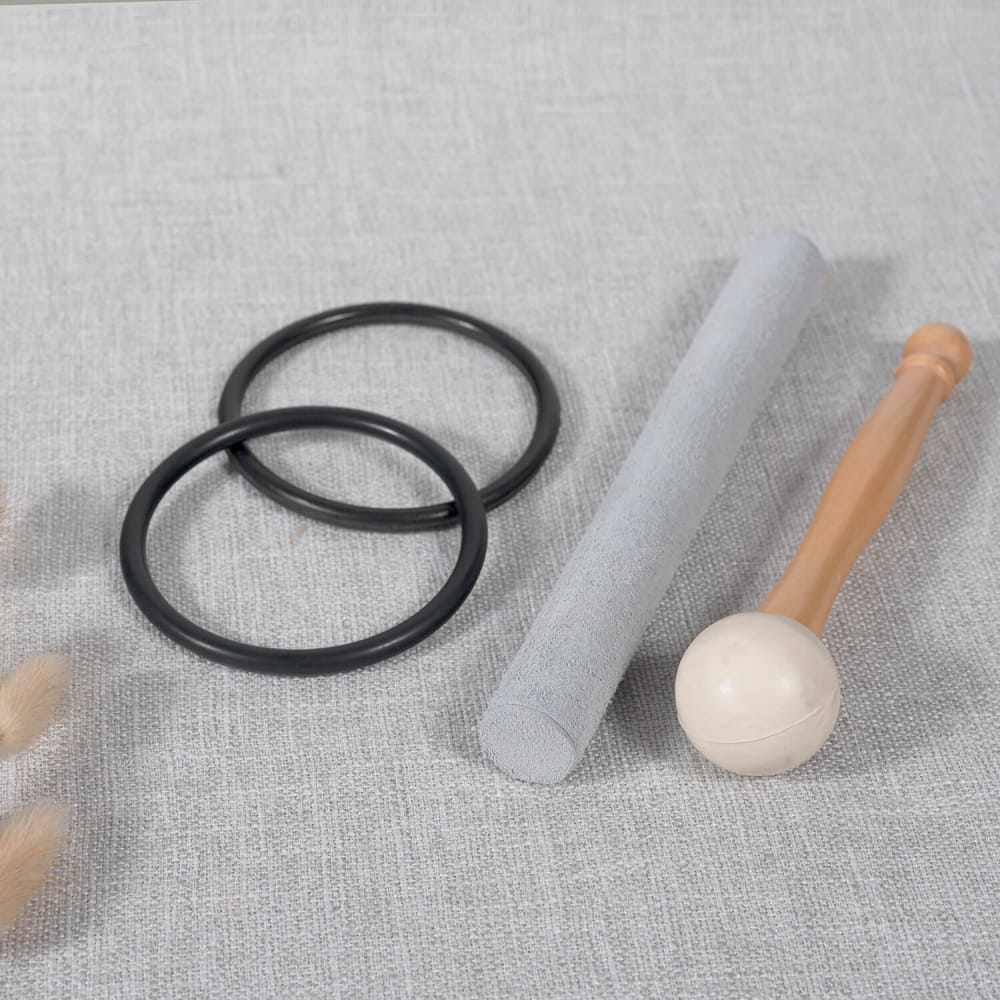 Two black rubber O-rings, gray cylinder, and wooden mallet for Earth Star & Soul Star bowls