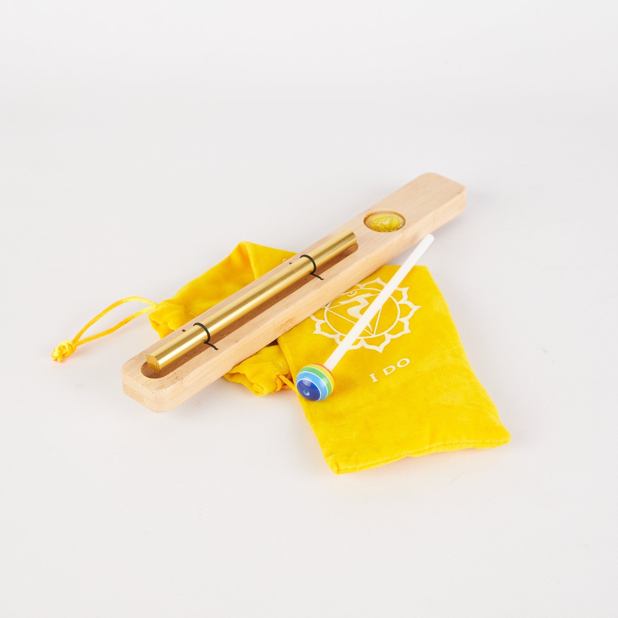 Golden metal massage tool with wooden handle and yellow pouch for Energy Bar Chimes