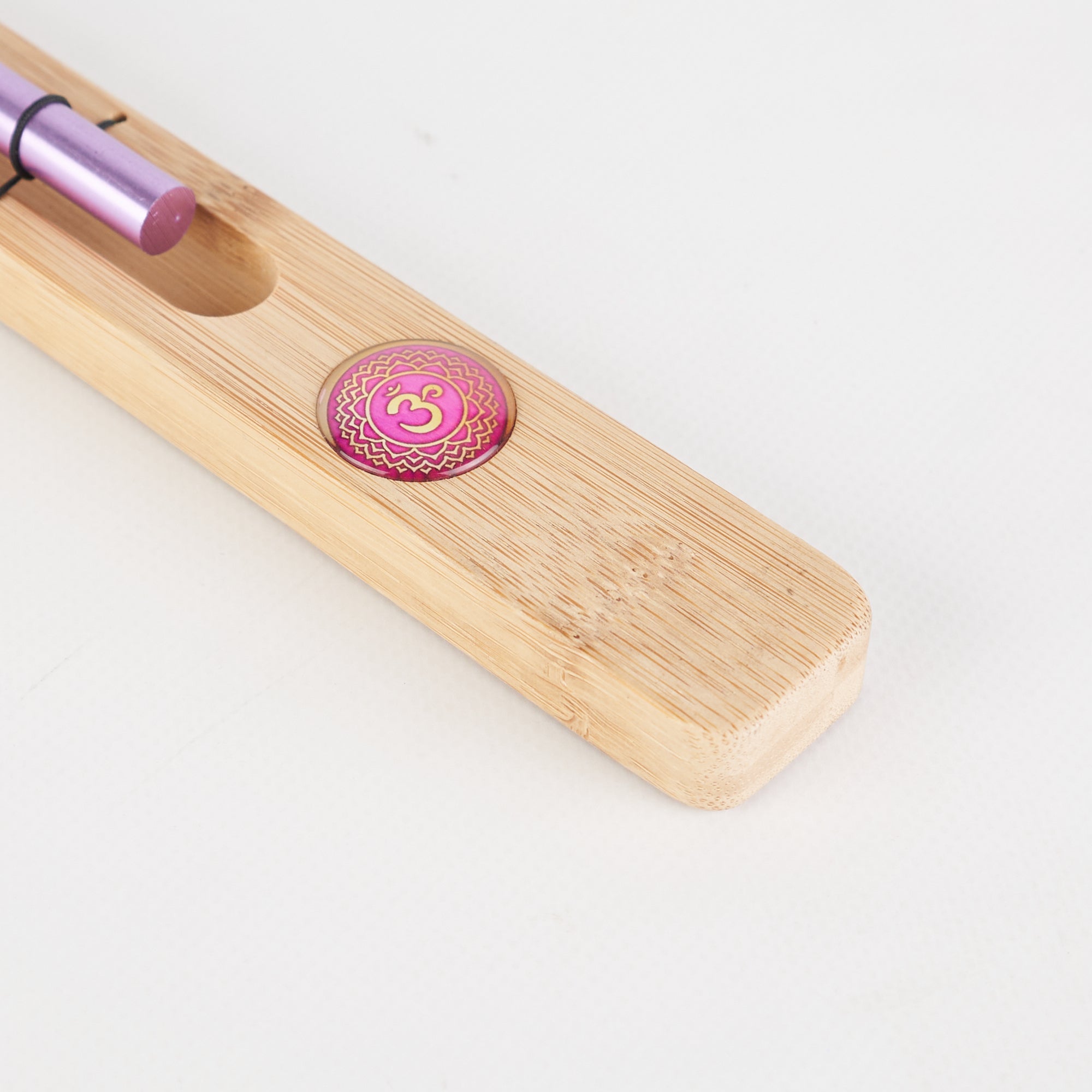 Wooden incense holder with pink medallion and purple base for chakra meditation