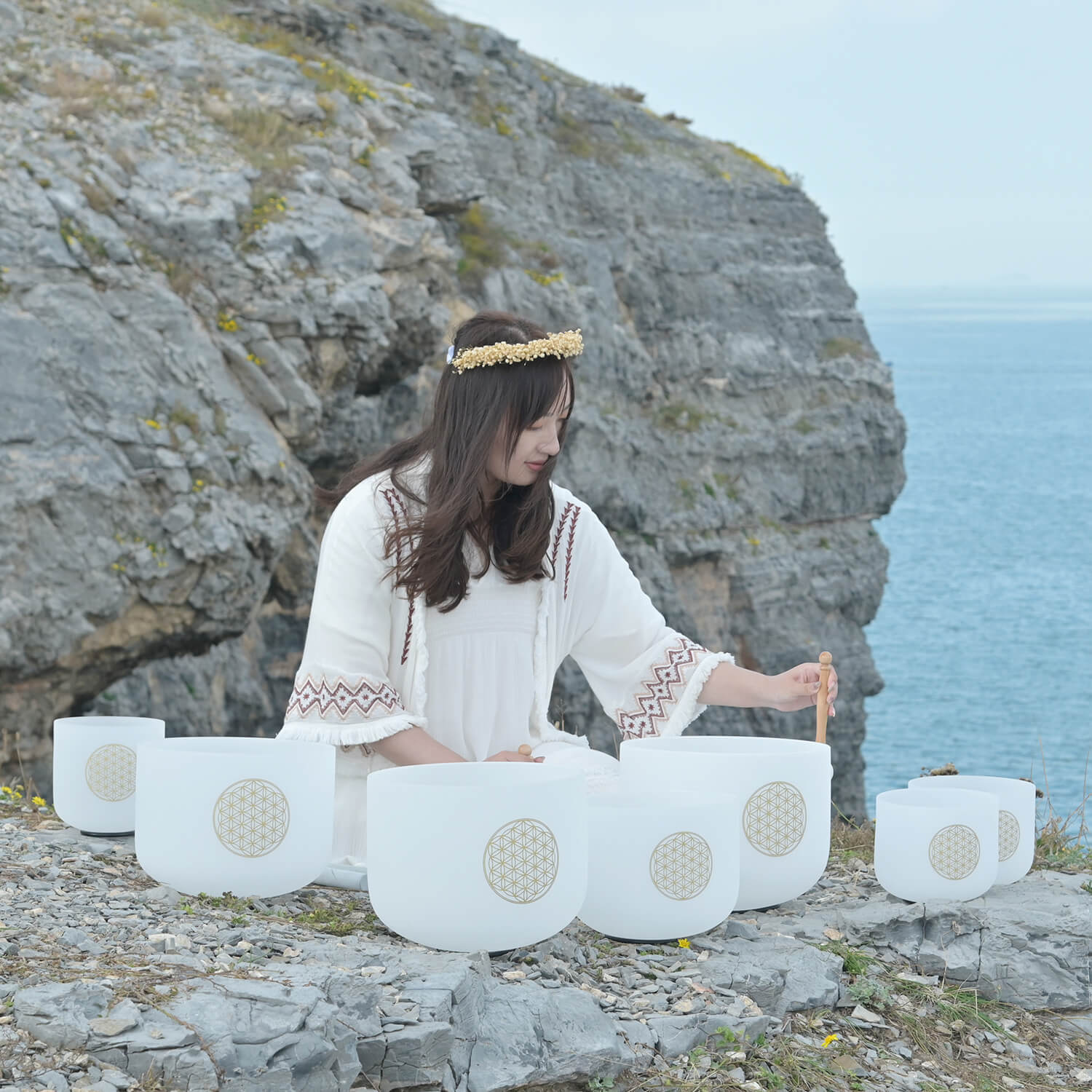 Crystal singing bowls with sacred geometry on coastal rocks for deep meditation