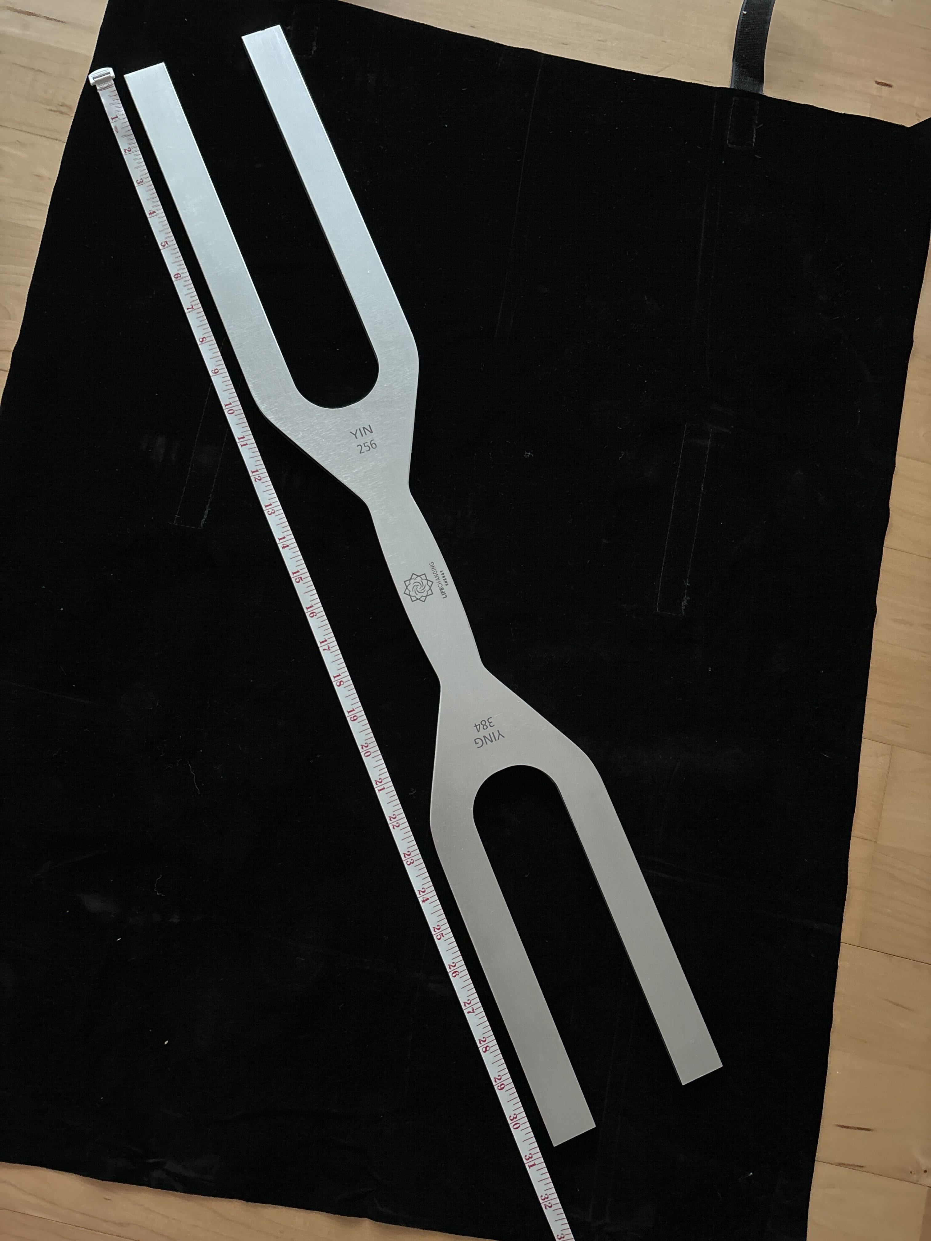 Metallic tuning fork on black surface from Giant Tuning Forks - Single and Double-Sided