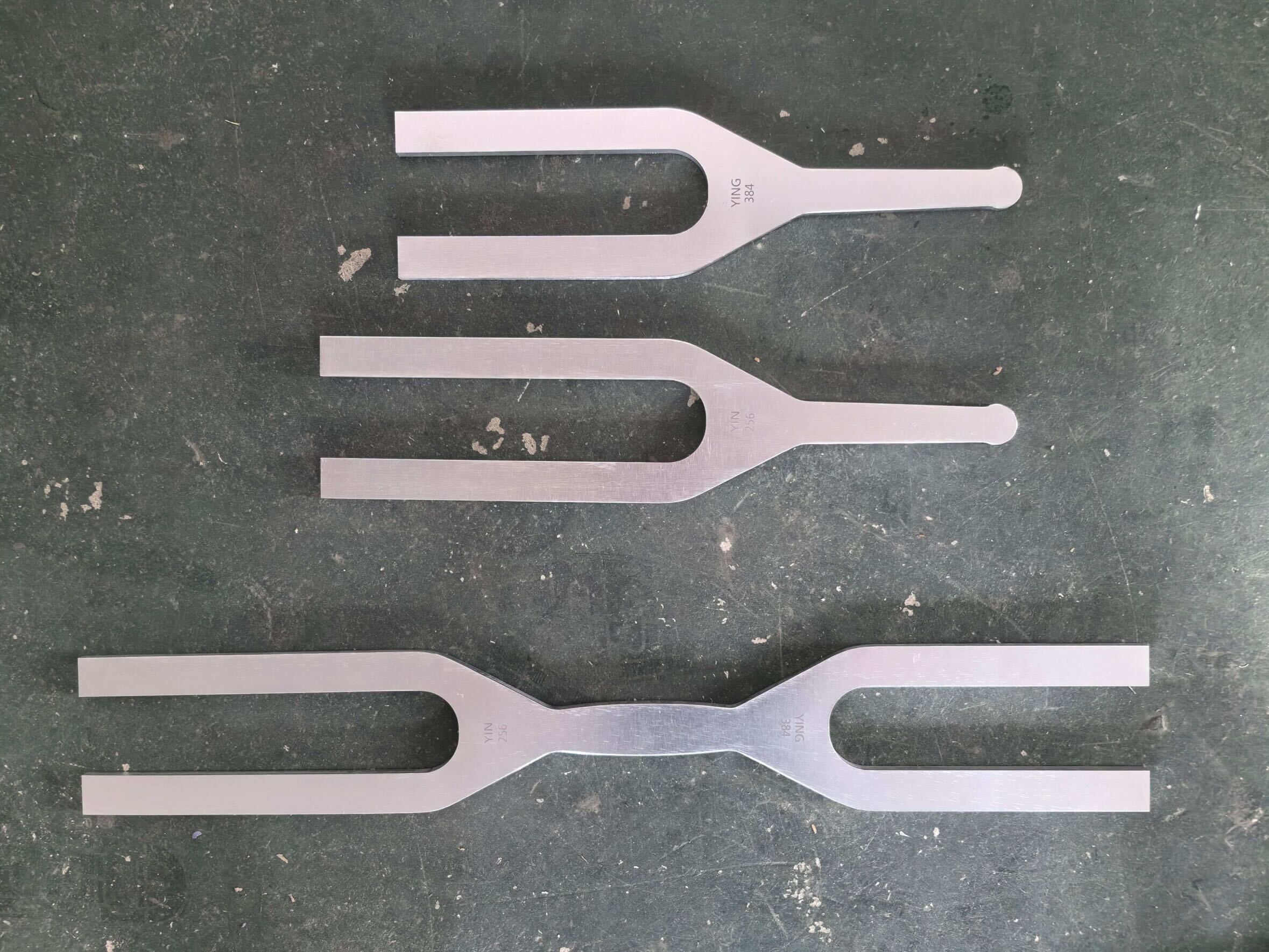 Three Giant Tuning Forks on a surface, showcasing single and double-sided designs