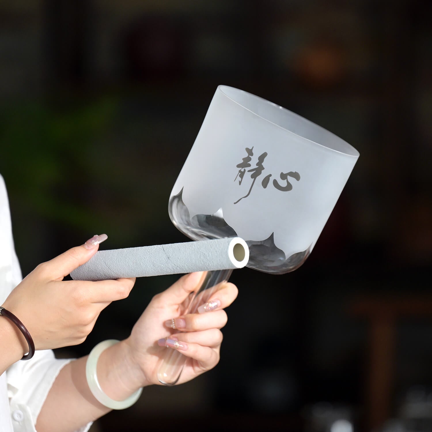 Paper scroll with Chinese calligraphy unrolled next to Handle Heart Crystal Singing Bowl