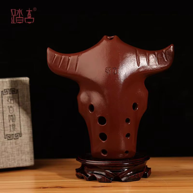 Brown ceramic 10-hole Xun wind instrument on wooden stand for musical enthusiasts