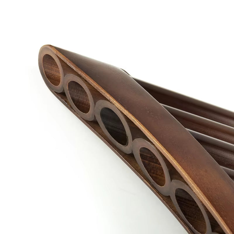 Brown leather wallet with circular cutout pattern next to Handmade Bamboo Pan Flute