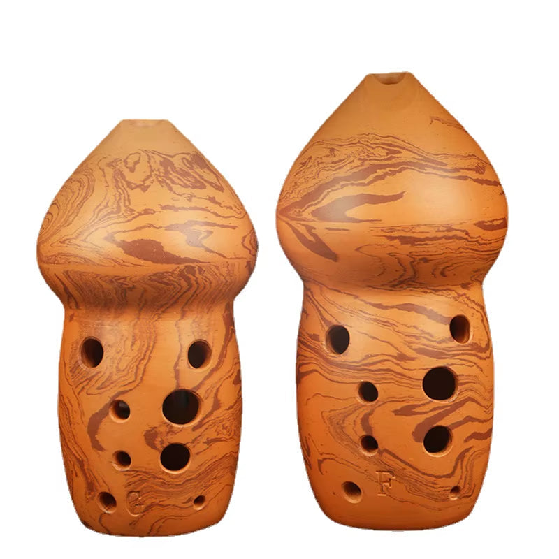 Two marbled terracotta ocarina flutes with finger holes in handmade ceramic design