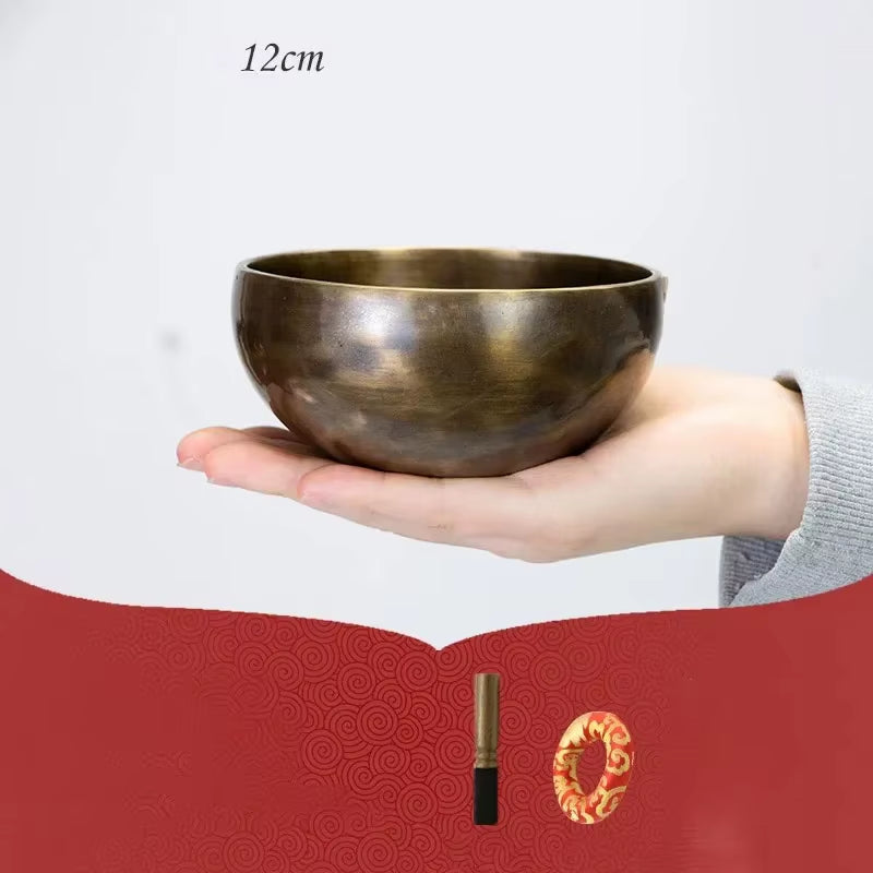 Bronze Tibetan singing bowl resting on an outstretched palm for meditation use