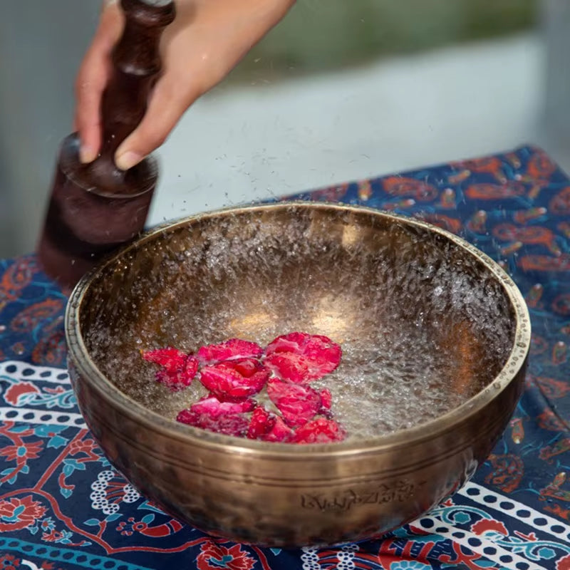 Handmade Full Moon Tibetan Singing Bowl filled with vibrant pink rose petals