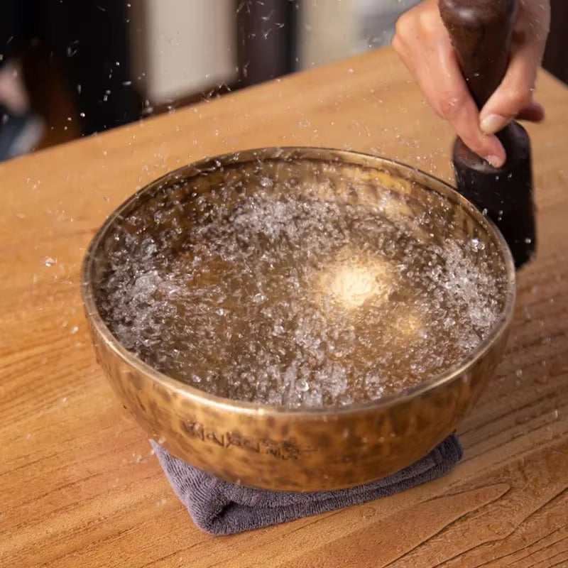 Copper bowl filled with bubbling liquid on a cloth napkin for Handmade Tibetan Singing Bowl