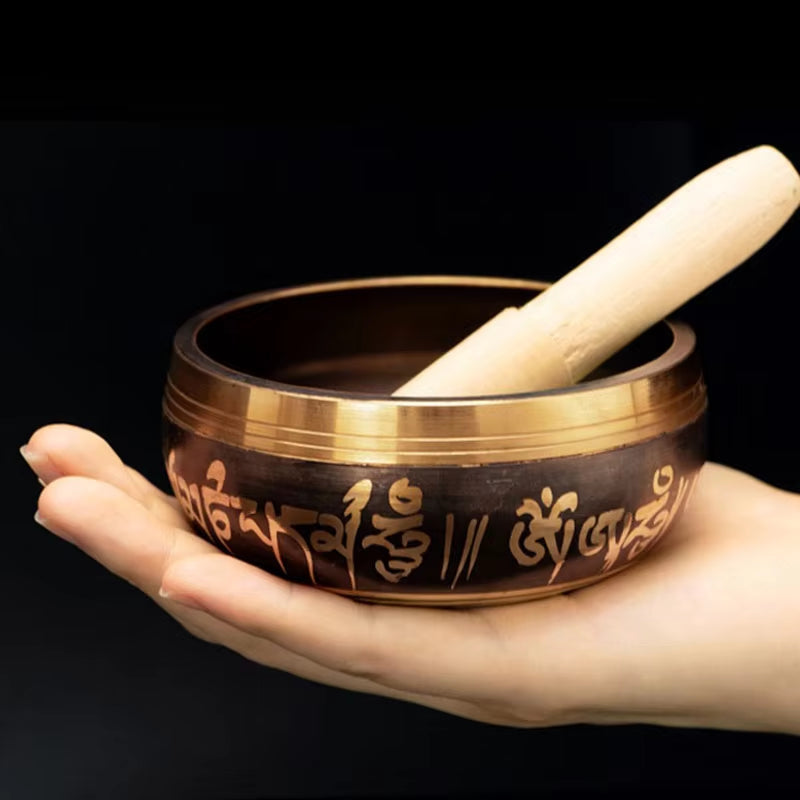 Handmade Tibetan Singing Bowl with decorative script and wooden striker for meditation therapy