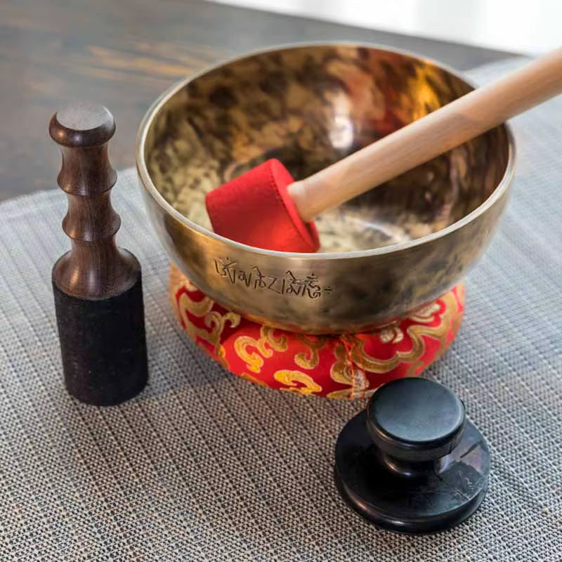 Handmade Tibetan Sound Bowl on a red cushion with a mallet for healing practices