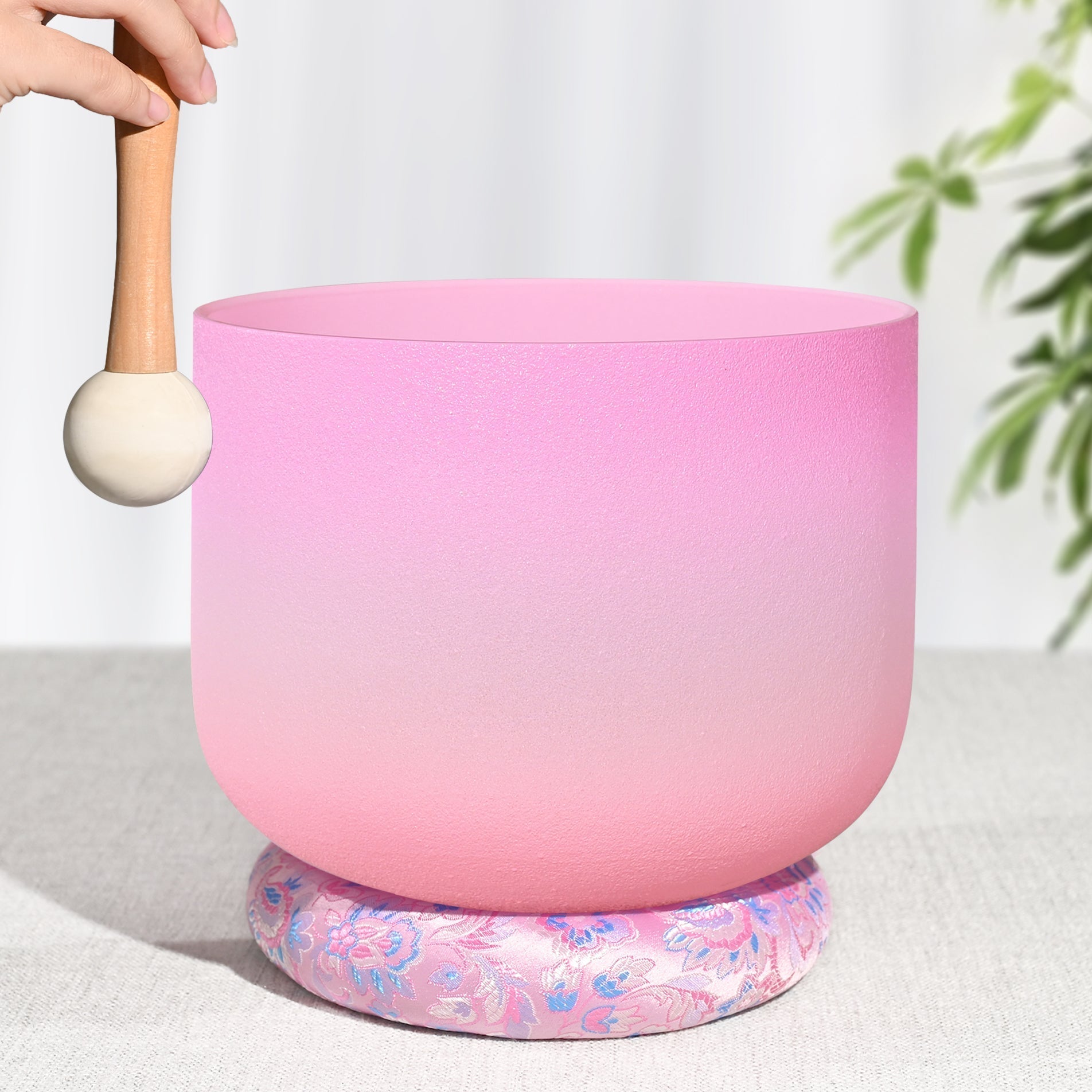 Pink frosted Heart Chakra Quartz Crystal Singing Bowl on floral cushion with wooden mallet